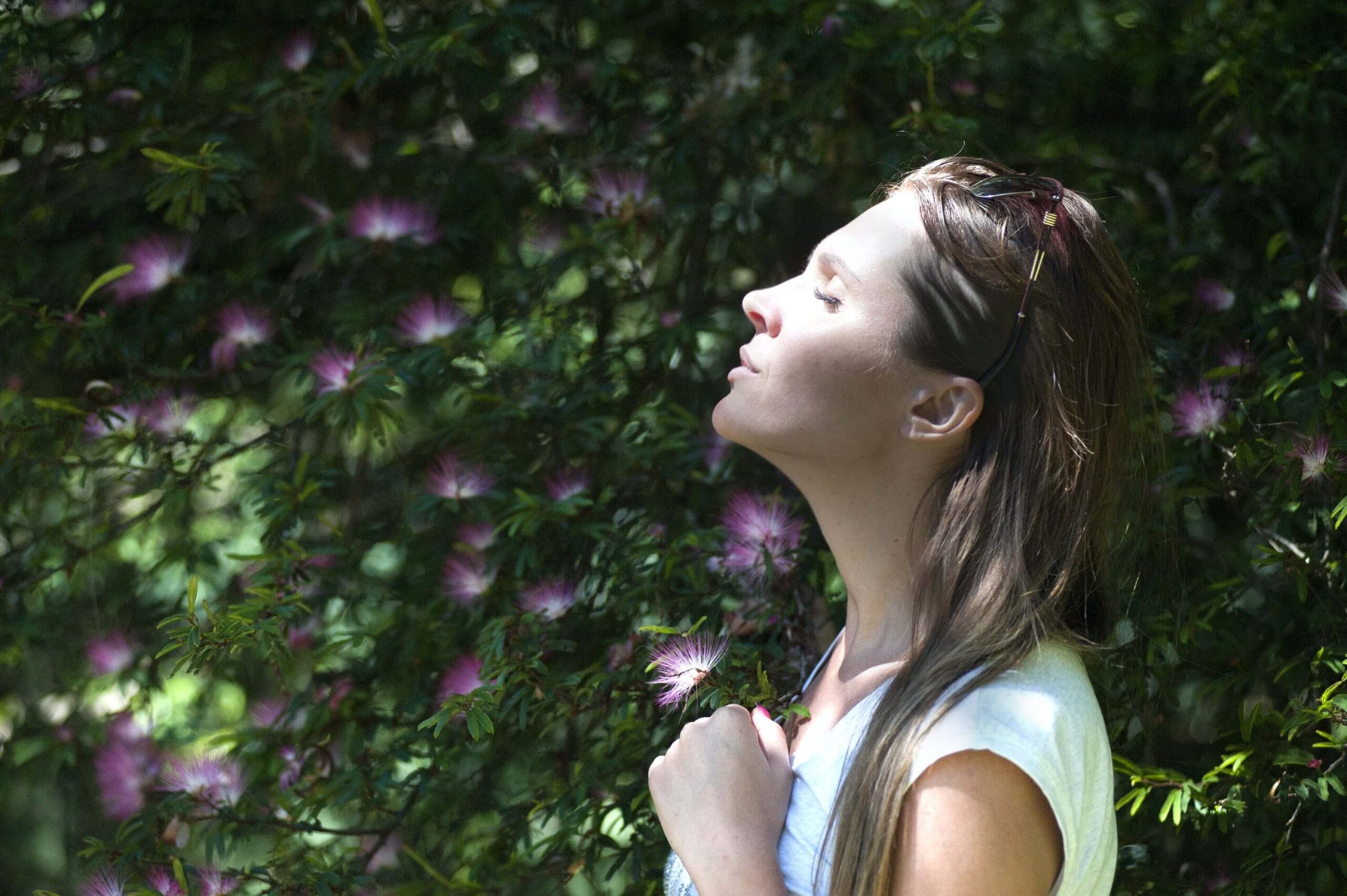 Lady looking up to the sun with her eyes closed